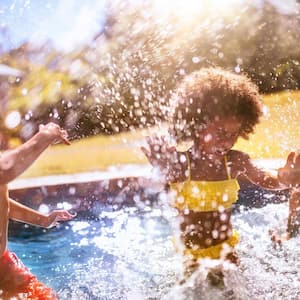 Friends playing in the pool in the backyard