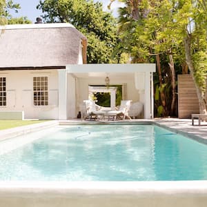 A swimming pool in a backyard surrounded by trees