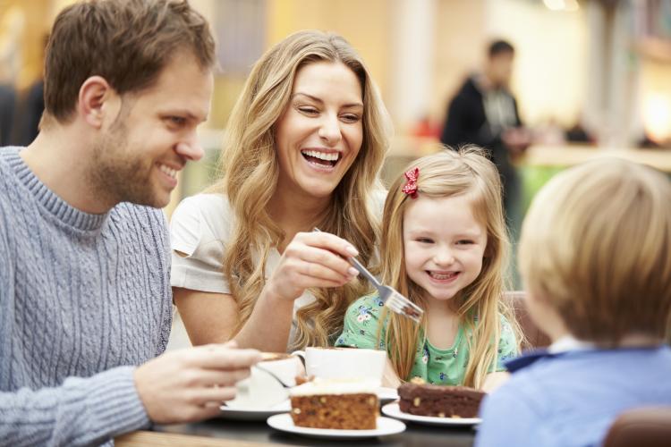 Family enjoying cake in café together.