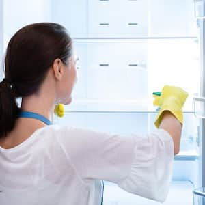 Woman cleaning refrigerator