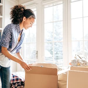 woman cleaning and boxing up belongings 