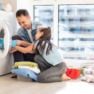 father daughter doing laundry at home 