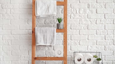 Wooden towel ladder against a brick wall