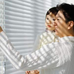 A father showing to his daughter the motorized blinds