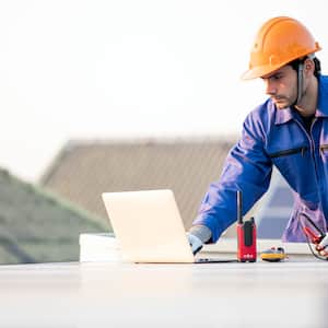 A worker checking the solar panels on the roof