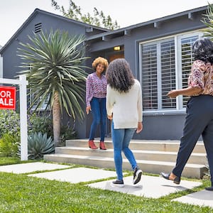 woman greeting people for a house tour