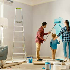 A family painting a wall with blue paint