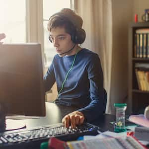 Teen boy playing video games on the computer