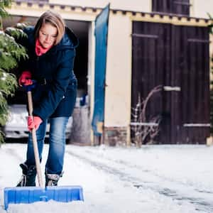 Woman shoveling snow in yard