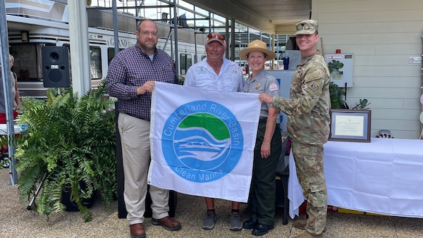 Mid-Cumberland Area Operation Manager Terrell Stoves presents Dale Hollow State Park Marina General Manager Glen Stone the Clean Marina flag, with the help of Clean Marina Coordinator and Dale Hollow Park Ranger Sondra Carmen, and Nashville District Commander Lt. Col. Joseph Sahl. The Clean Marina ceremony was held Aug. 6, 2022, at The Dale Hollow State Park Marina in Burkesville, Kentucky.