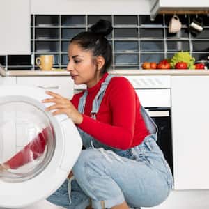 A woman opening the door of the washing machine