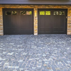 brown double garage doors and stone paved driveway