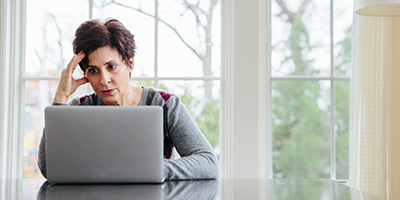 Exhausted-looking woman at a laptop