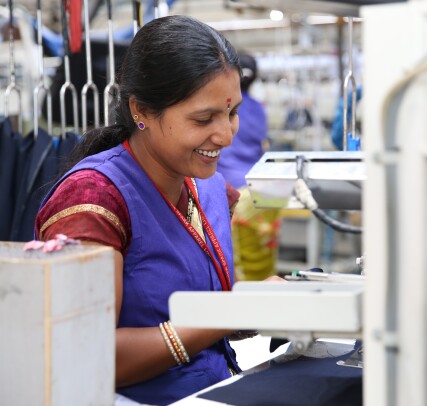 Seamstress smiles at work in a factory