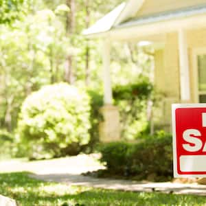 A home for sale with a real estate sign in front of it