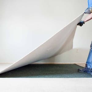 Man removing carpet during home renovations.