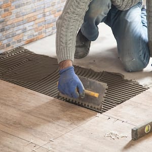 Man laying a new ceramic tile floor