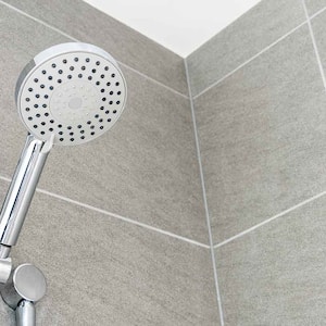 A view of a shower with gray tile