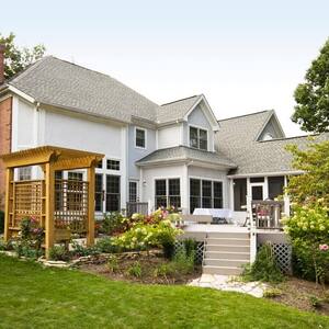 A backyard of a house with a wooden trellis