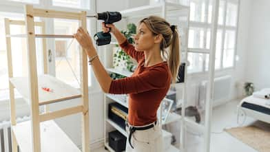 woman drilling a wooden shelf