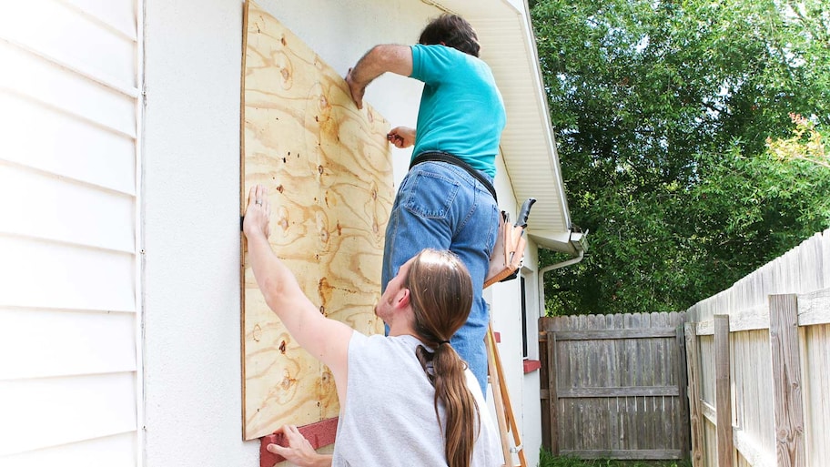 Father and son make house preparations for upcoming hurricane