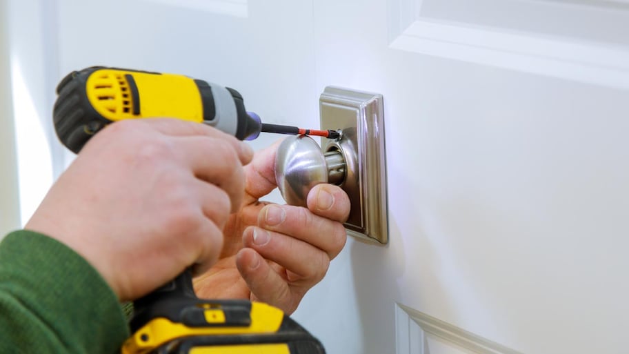 A man installing a new door lock