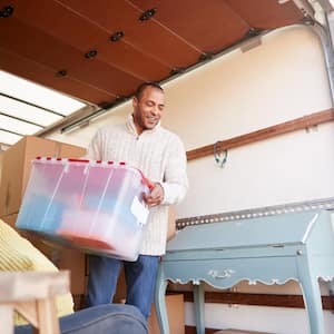 Man unloading moving truck outside of house