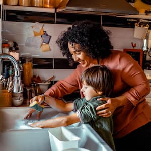 A mother with her son doing the dishes