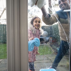 Father and daughter cleaning outside windows