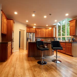 home kitchen with island and bar stools, wood accents, and recessed lighting