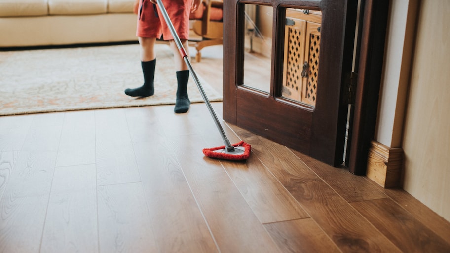 Close-up of a woman’s hand wiping a hardwood floor