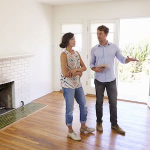 Man and woman standing look over living room