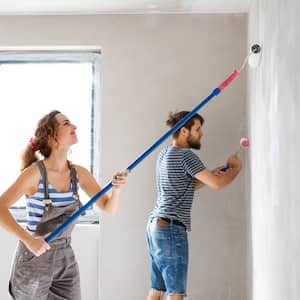 A young couple paints a wall