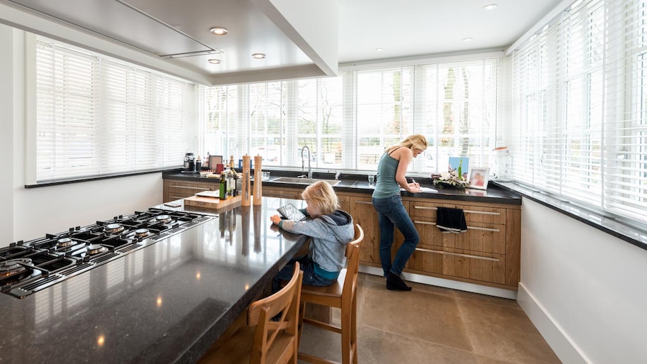 A mother and a daughter in modern kitchen with granite countertop