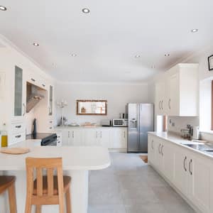 A spacious and bright kitchen with white cabinets