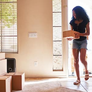 A woman moving in new house carrying a cardboard box