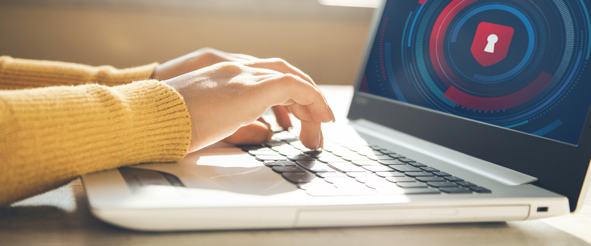 Hands typing on a laptop keyboard with a lock image on the screen