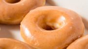A row of glazed yeast donuts.