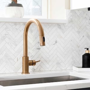 A view of a kitchen with herringbone tile backsplash