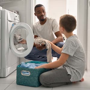 A father and his son loading the washing machine with clothes