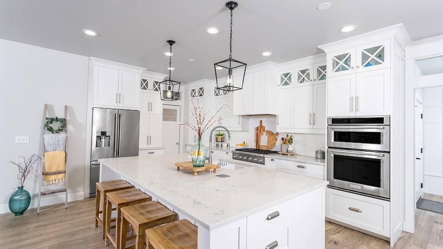 Modern farmhouse kitchen with white marble counters and cabinets