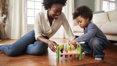 Mother and son sitting on the floor playing together