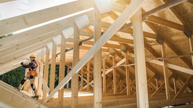 Man builds the wooden roof of a barn