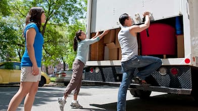 Friends helping to unload moving truck