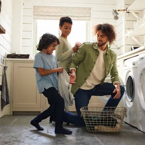 A father with his sons loading the washing machine