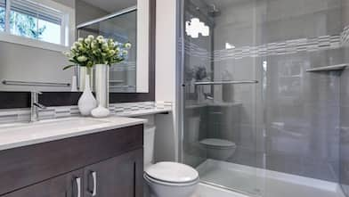 A bright new bathroom interior with glass walk in shower