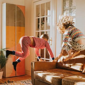 Children jumping on a leather sofa