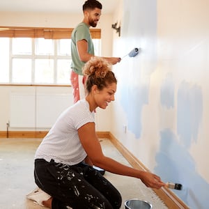 Couple together adding fresh paint to walls