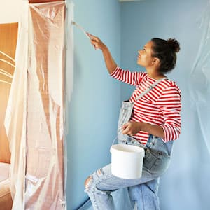 A pregnant woman painting a room