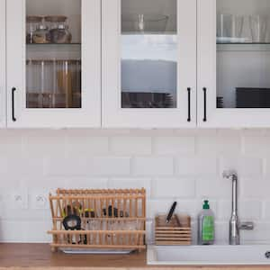 A Scandinavian style kitchen with glass door cabinets